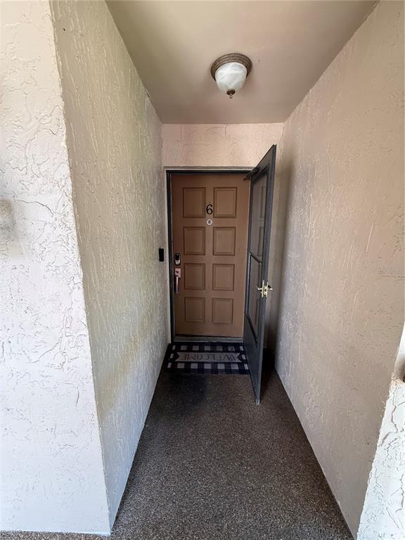 A brown front door with the number six is set within a recessed entryway — 7015 COGNAC DRIVE UNIT 6, NEW PORT RICHEY, FL