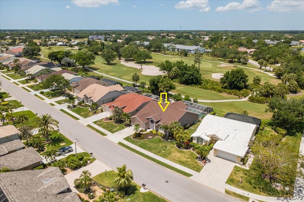 An aerial view shows a suburban house with a brown roof overlooking a golf course — 7015 PLEASANT HILL ROAD, BRADENTON, FL