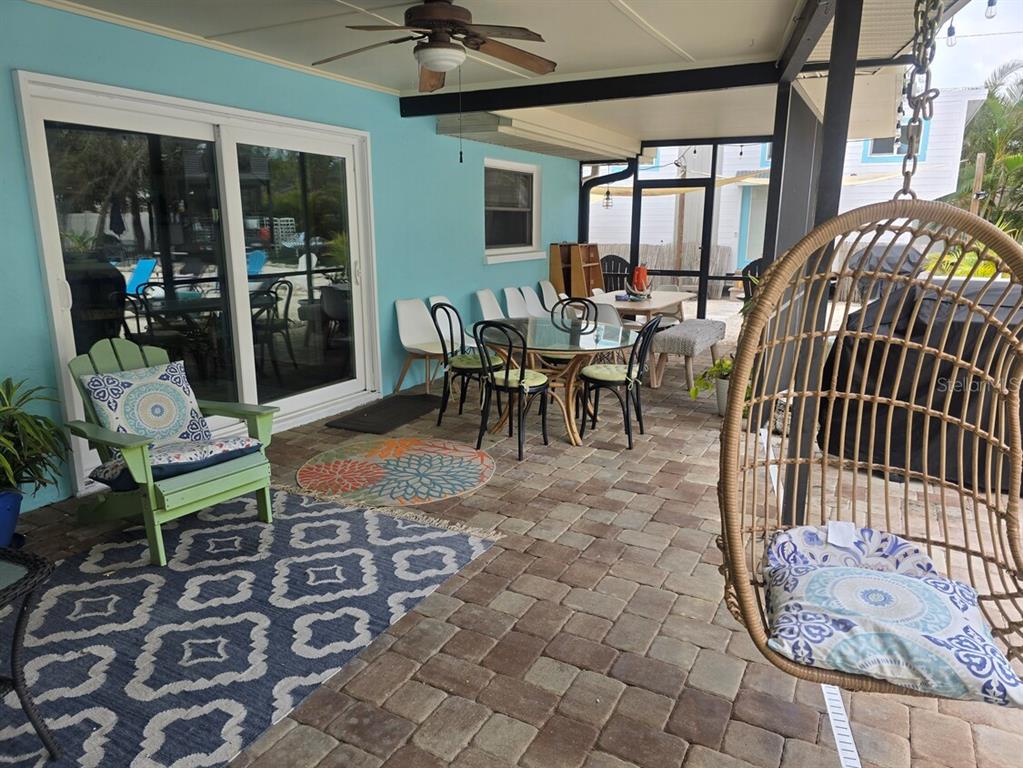 A swimming pool with a rock waterfall, slide, and attached spa on a paved patio — 108 W 75TH STREET, BRADENTON, FL