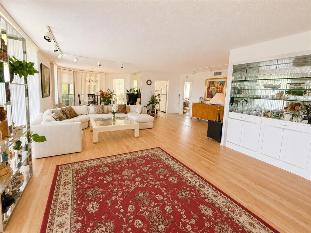 A kitchen features light-colored cabinetry, stainless steel appliances, and a dining table with chairs — 4770 FOUNTAINS DRIVE S UNIT 302, LAKE WORTH, FL