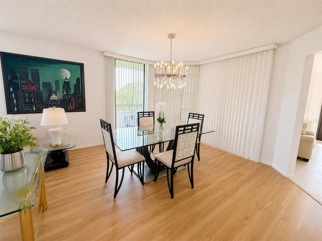 A spacious living room features light wood flooring, a large sectional sofa, and floor-to-ceiling windows — 4770 FOUNTAINS DRIVE S UNIT 302, LAKE WORTH, FL
