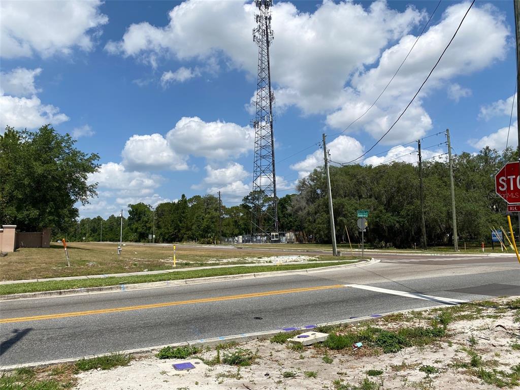 A tall communication tower stands near a road intersection with a stop sign — 8357 BELLA CITTA BOULEVARD, DAVENPORT, FL