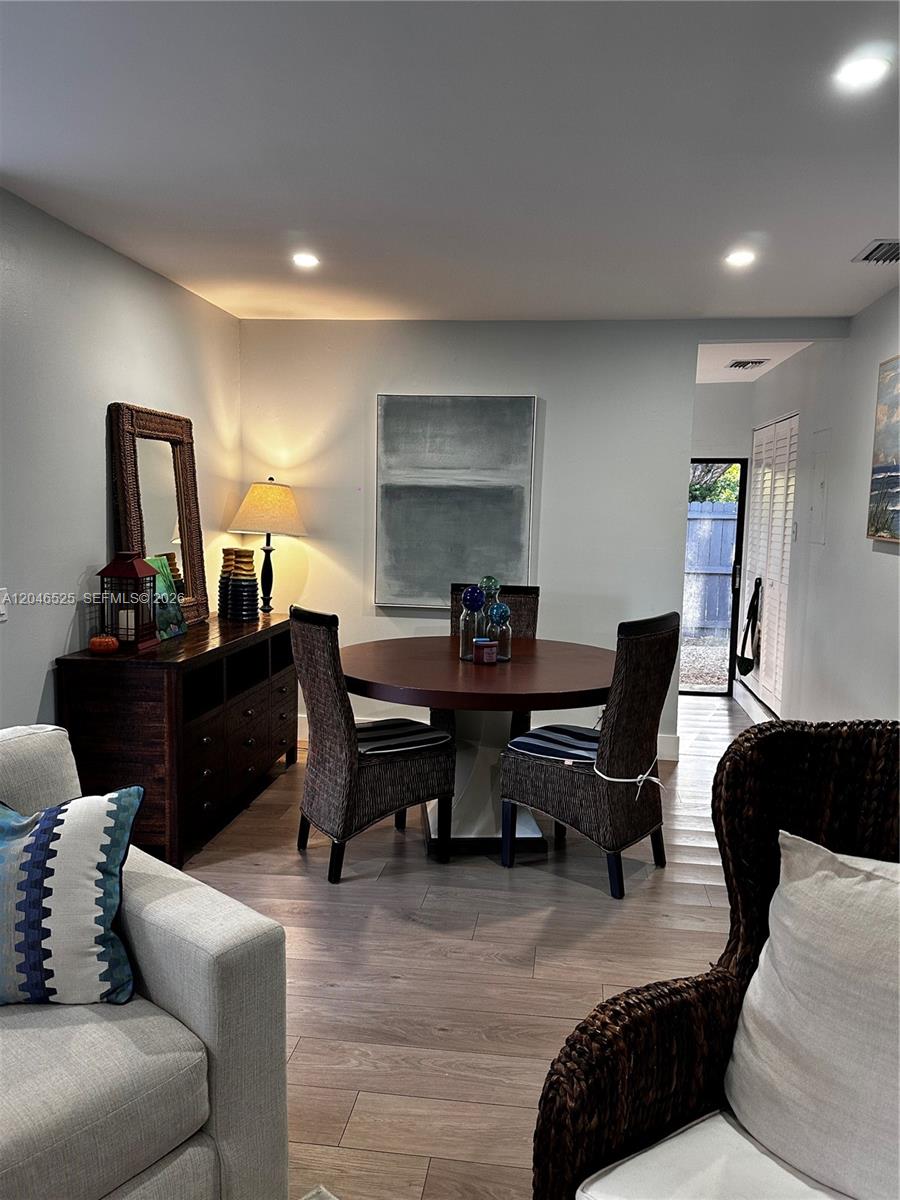 A dining area features a round wooden table, wicker chairs, and a dark wood sideboard — 3793 SW 28th St # 3793, Miami FL 33134, MIAMI, FL