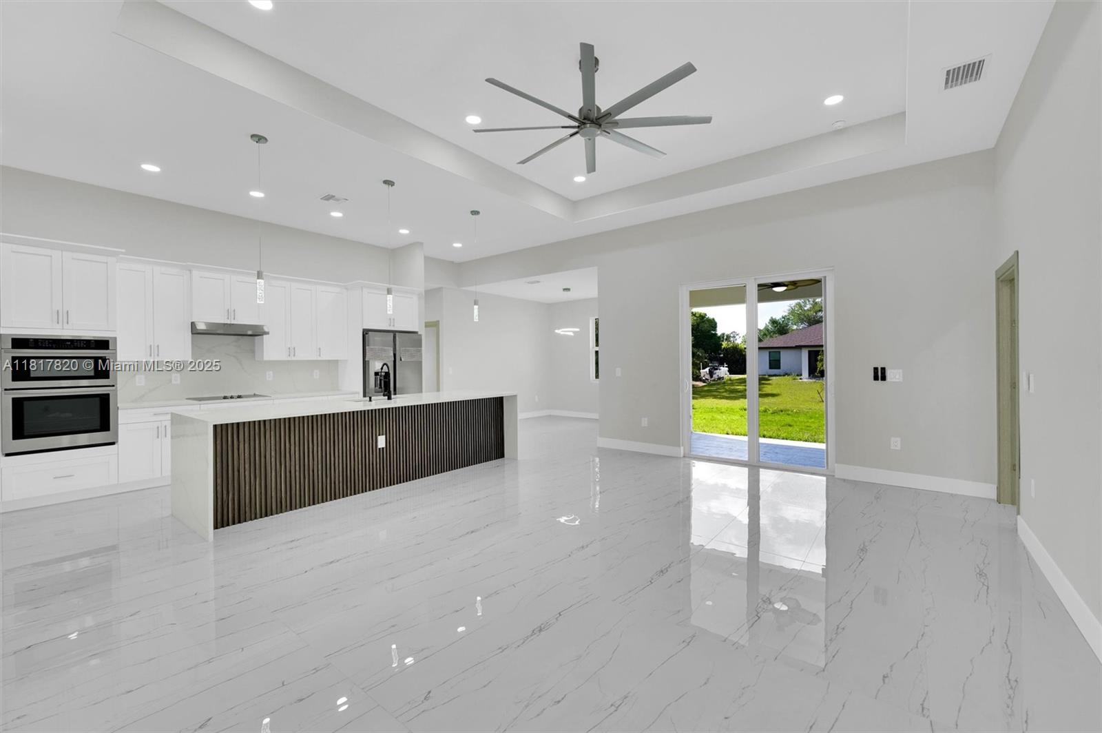A modern kitchen with white cabinets, a slatted island, and marble-look tile flooring — 2807 40 ST W, Lehigh Acres FL 33971, LEHIGH ACRES, FL