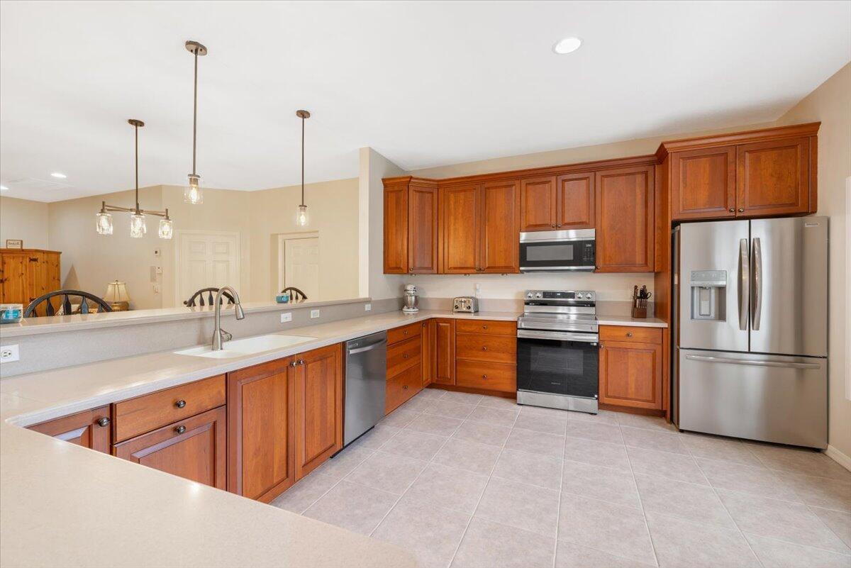 A kitchen features wood cabinets, stainless steel appliances, and a peninsula with a sink — 1410 4th Court, Vero Beach FL 32960, VERO BEACH, FL