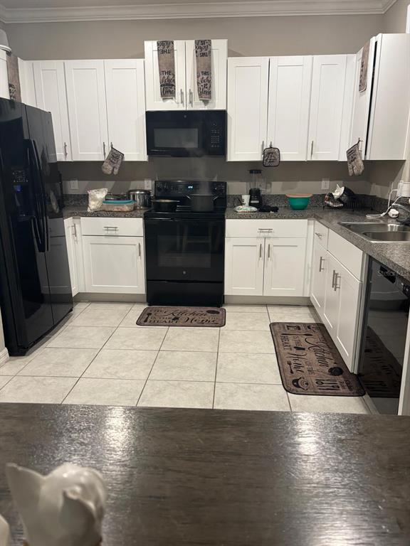 A kitchen features white cabinets, black appliances, granite countertops, and light-colored tile flooring — 11813 DUMAINE VALLEY ROAD, RIVERVIEW, FL