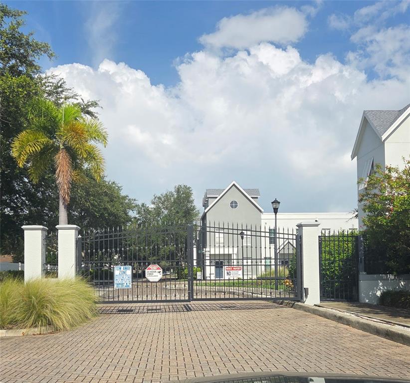 A covered balcony with white railings overlooks a paved street and surrounding trees — 4511 LEGACY PARK DRIVE, TAMPA, FL