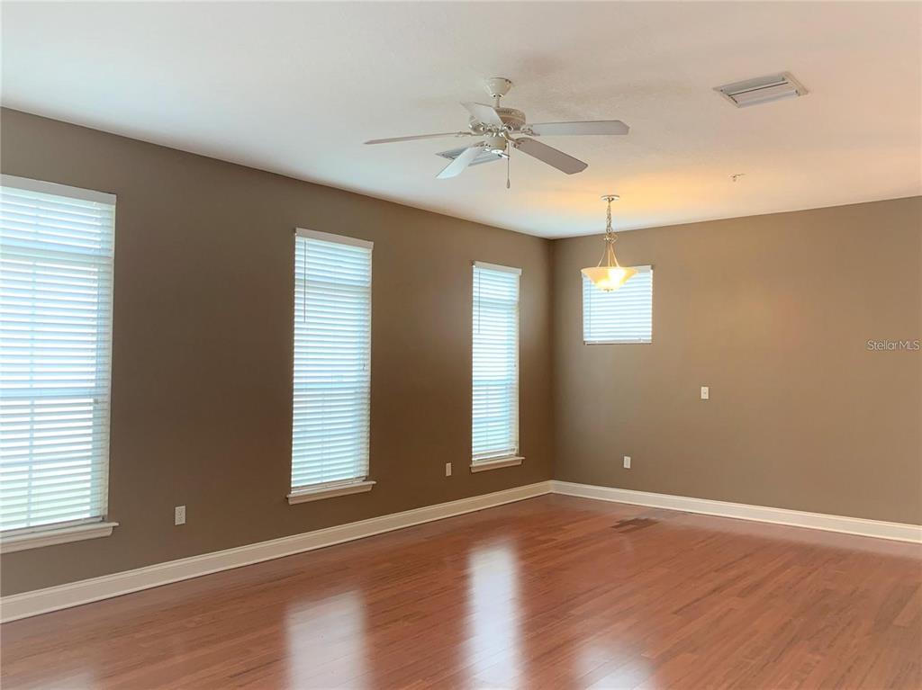A kitchen with wood cabinets, granite countertops, stainless steel appliances, and a tiled backsplash — 4511 LEGACY PARK DRIVE, TAMPA, FL
