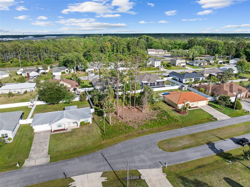 An aerial view shows a vacant residential lot situated between two houses in a neighborhood — 7 ZEALAND PLACE, PALM COAST, FL