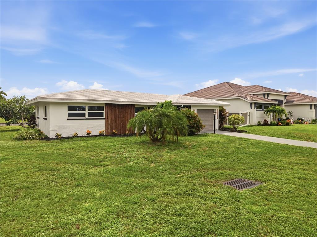 A single-story white house with a wood-paneled accent wall and a front-facing garage — 3106 SE 18TH PLACE, CAPE CORAL, FL
