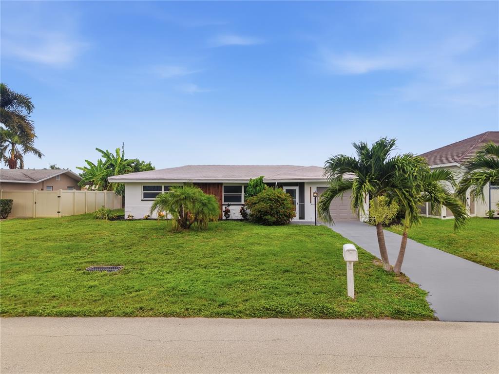 A single-story house with a white exterior, a gray roof, and a palm tree-lined lawn — 3106 SE 18TH PLACE, CAPE CORAL, FL