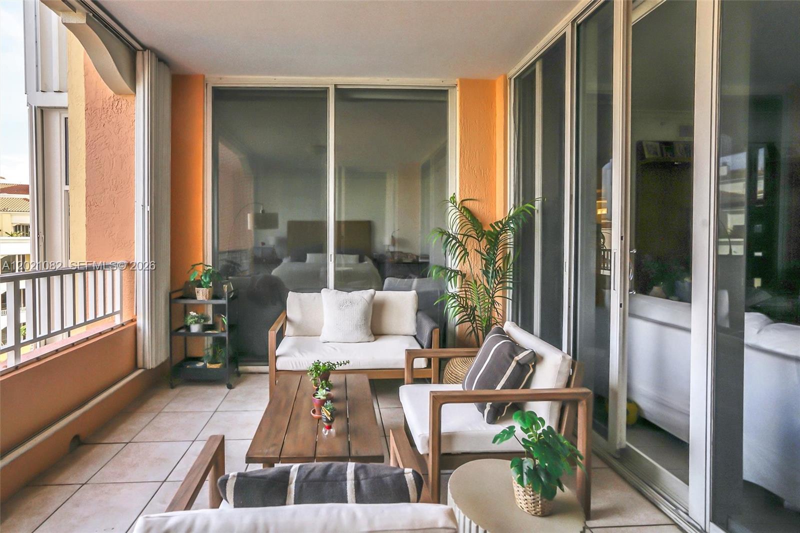 A balcony features outdoor furniture, potted plants, and sliding glass doors leading into a room — 735 Crandon Blvd # 503, Key Biscayne FL 33149, KEY BISCAYNE, FL