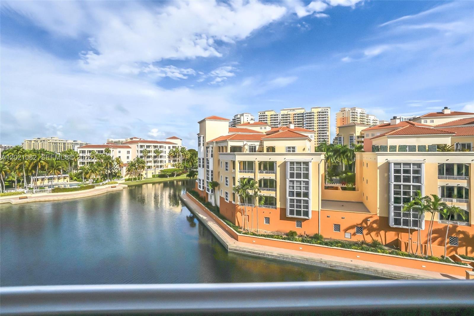 An elevated view of a canal winding between Mediterranean-style apartment buildings under a blue sky — 735 Crandon Blvd # 503, Key Biscayne FL 33149, KEY BISCAYNE, FL