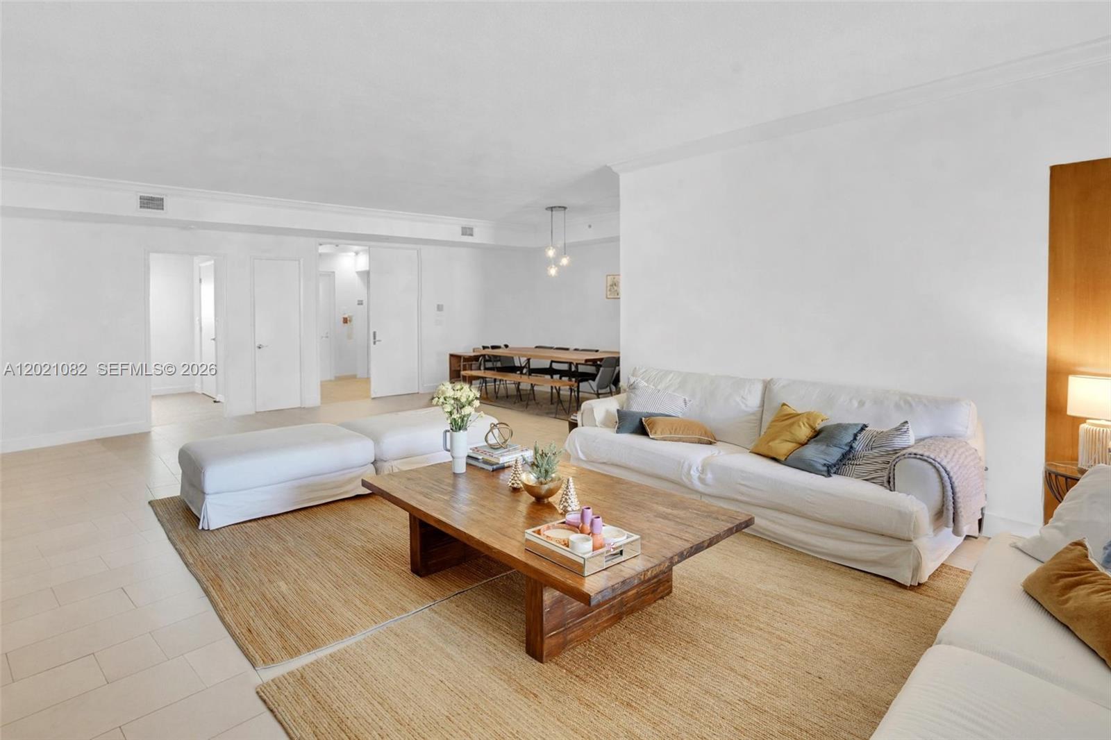 A living room features a white sofa, a large wooden coffee table, and a dining area — 735 Crandon Blvd # 503, Key Biscayne FL 33149, KEY BISCAYNE, FL