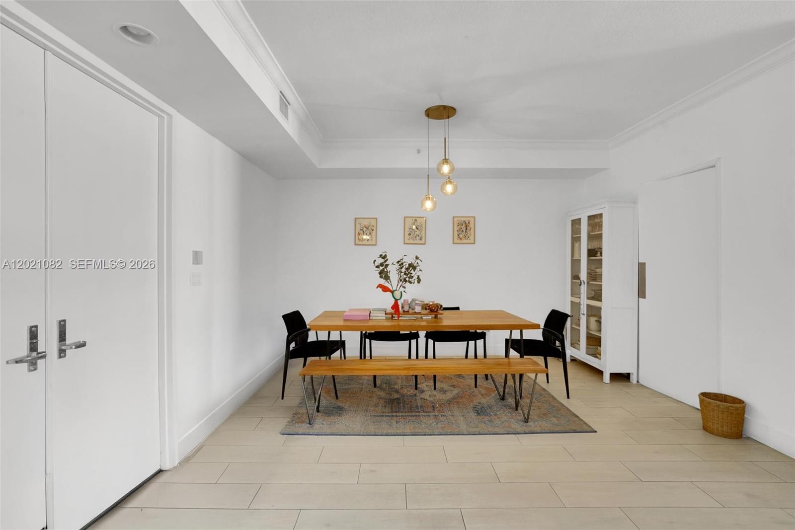 A dining room features a wooden table, a bench, black chairs, and a glass cabinet — 735 Crandon Blvd # 503, Key Biscayne FL 33149, KEY BISCAYNE, FL