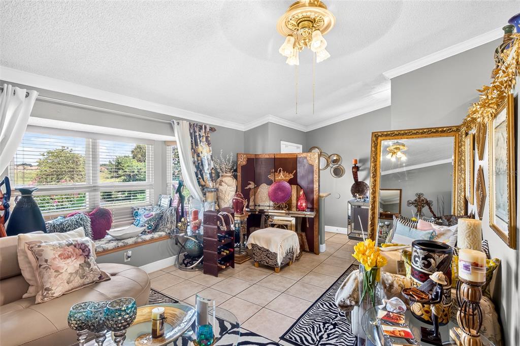 A living room features tile flooring, a bay window with a seat, and ornate gold-framed mirrors — 6616 CORAL COVE DRIVE, ORLANDO, FL