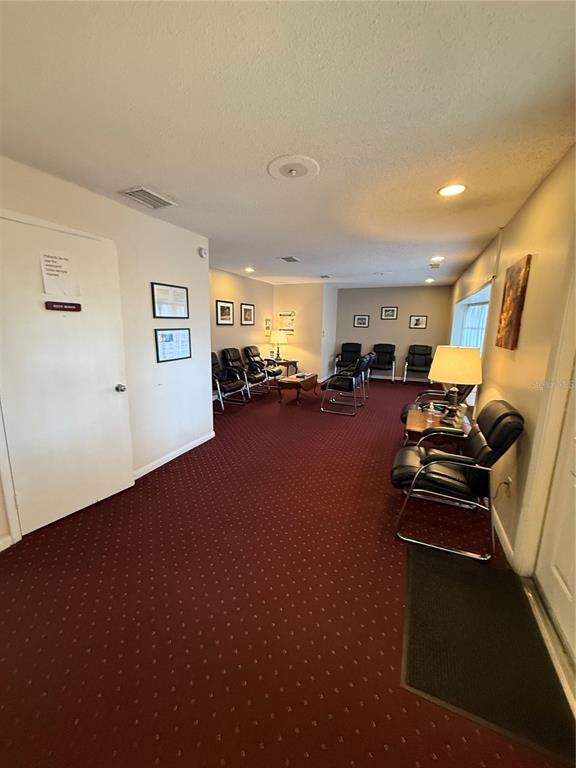 A waiting room features red carpeting, black chairs, and framed wall art — 28960 US HIGHWAY 19 N UNIT 110, CLEARWATER, FL