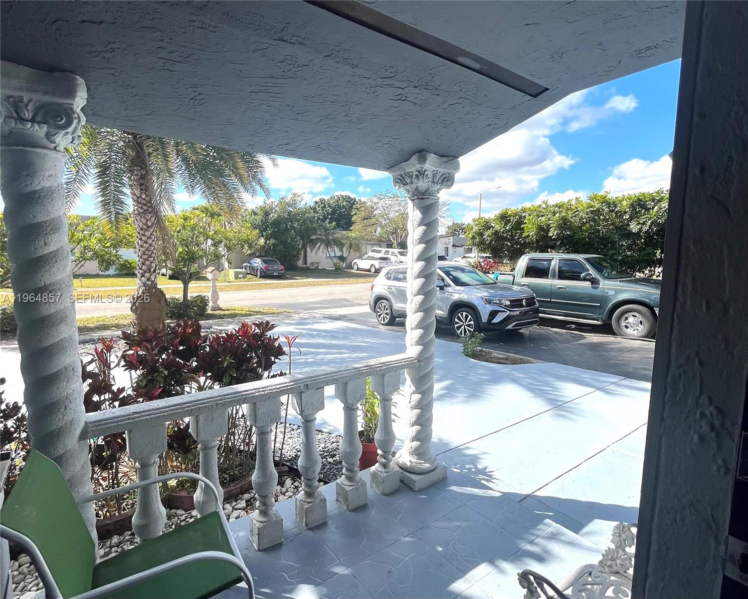 A covered porch features decorative columns, a balustrade, and a view of a driveway — 12271 SW 187th St, Miami FL 33177, MIAMI, FL