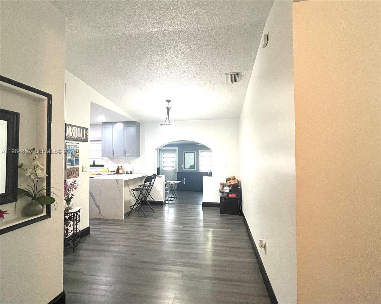 A hallway leads into an open-concept kitchen with a marble-topped island and gray flooring — 12271 SW 187th St, Miami FL 33177, MIAMI, FL