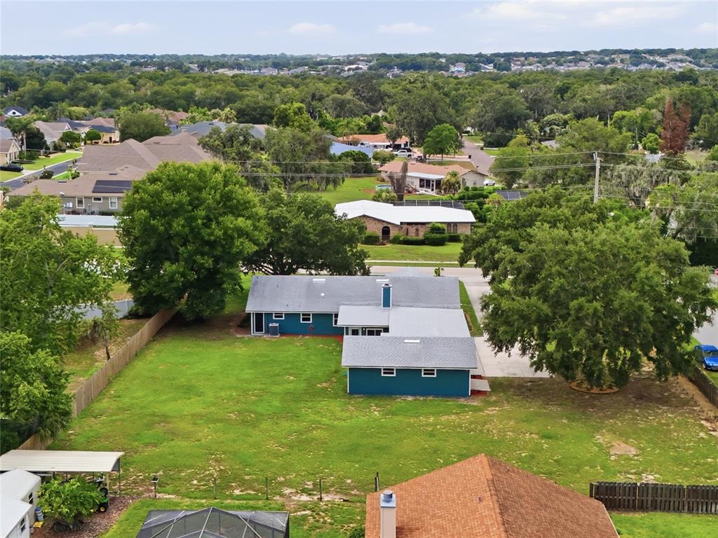 An aerial view shows a blue house with a gray roof and a large backyard — 6028 YARBOROUGH LANE, LAKELAND, FL