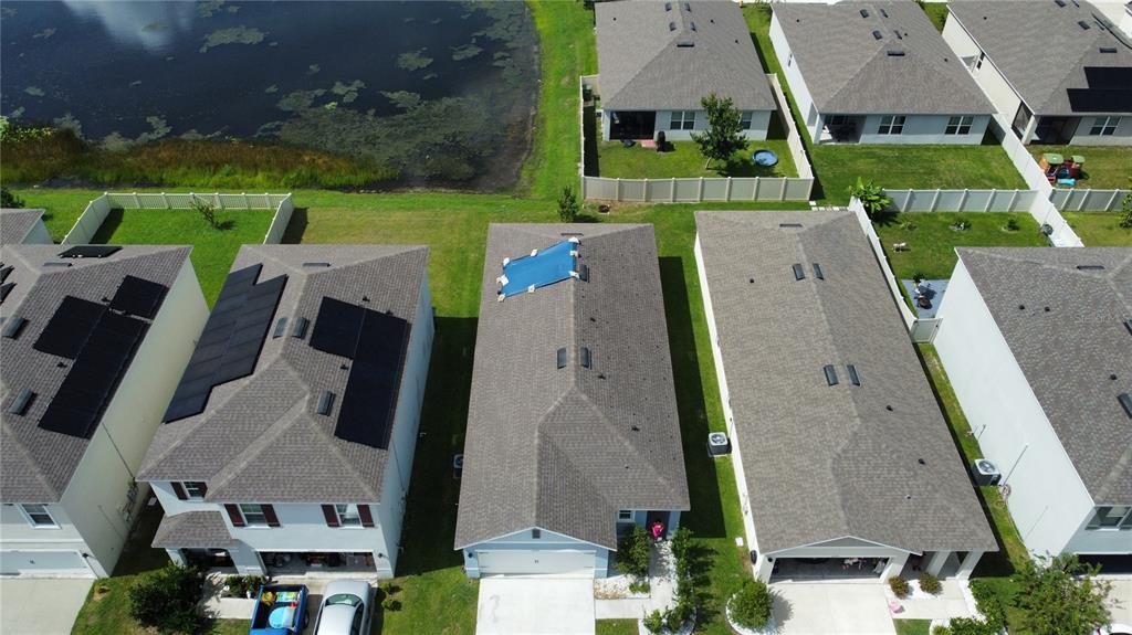 An aerial view shows several suburban houses with shingled roofs, including one with a blue tarp — 2375 BRASSIE COURT, WINTER HAVEN, FL