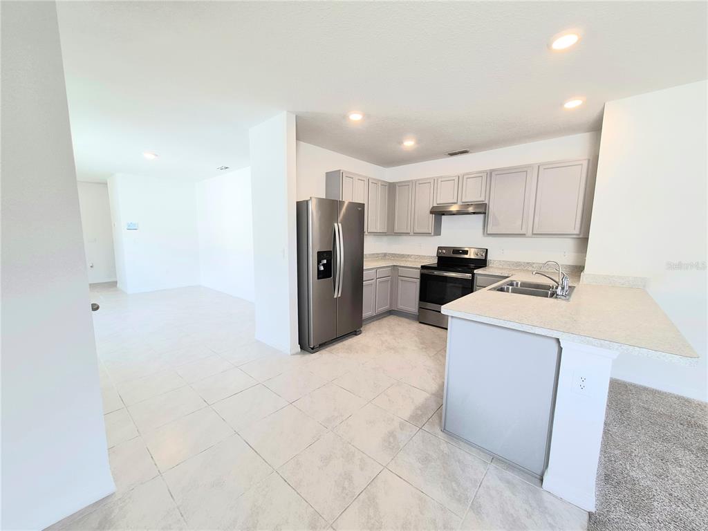A kitchen with light gray cabinets, stainless steel appliances, and tile flooring — 2375 BRASSIE COURT, WINTER HAVEN, FL