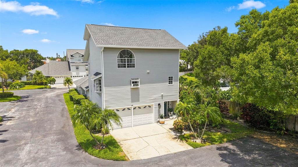 A two-story house with gray siding, a two-car garage, and a concrete driveway — 11722 CURRIE LANE UNIT J1, LARGO, FL