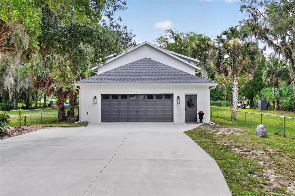 A white detached garage with a gray shingled roof and a concrete driveway — 9275 SW 186TH TERRACE, DUNNELLON, FL