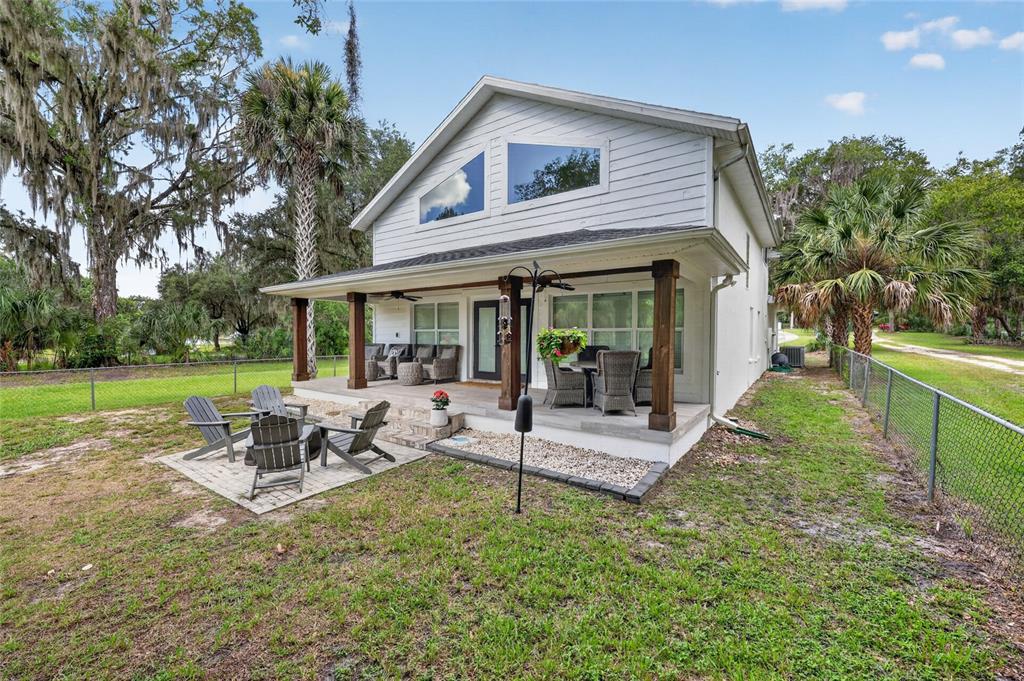 A two-story house with a covered patio, outdoor seating, and a stone paver area — 9275 SW 186TH TERRACE, DUNNELLON, FL
