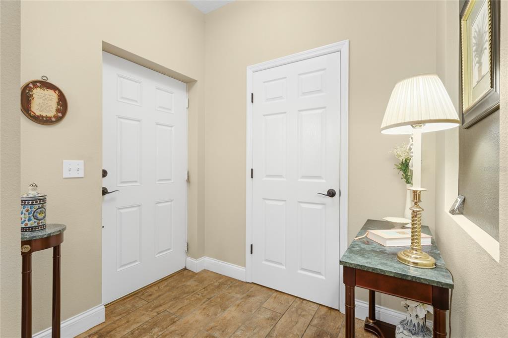 An entryway features tile flooring, two white doors, and two small tables with lamps — 6216 ROSEFINCH COURT UNIT 102, LAKEWOOD RANCH, FL