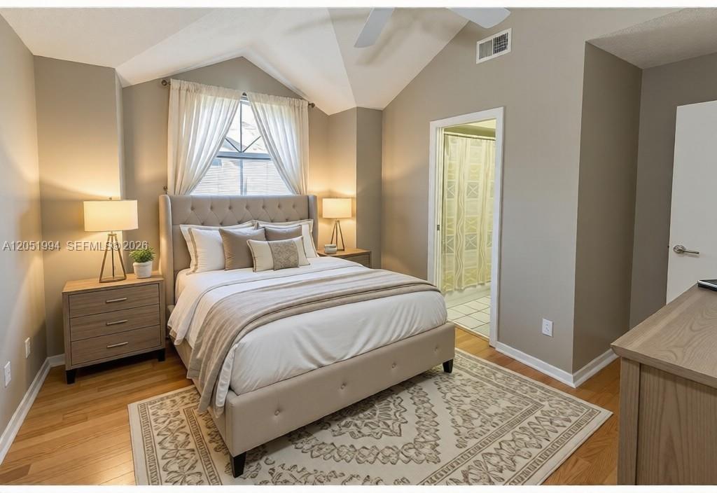 A bedroom features a tufted headboard, vaulted ceiling, wood flooring, and an attached bathroom — 606 S Albany Ave # 0, Tampa FL 33606, TAMPA, FL