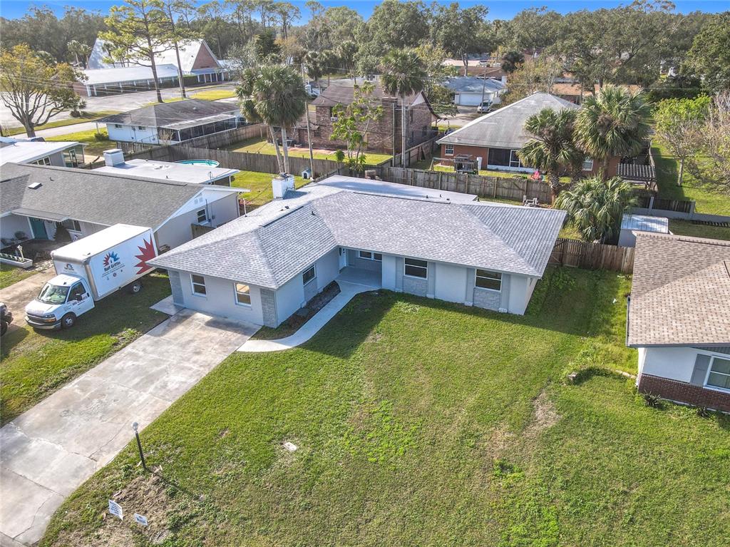 An aerial view of a single-story house with a gray roof and a concrete driveway — 1428 MARGINA AVENUE, DAYTONA BEACH, FL