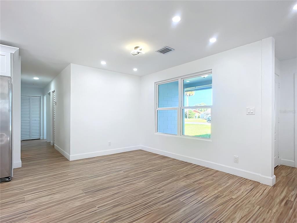 A bright dining area features white walls, recessed lighting, and wood-look flooring — 1428 MARGINA AVENUE, DAYTONA BEACH, FL