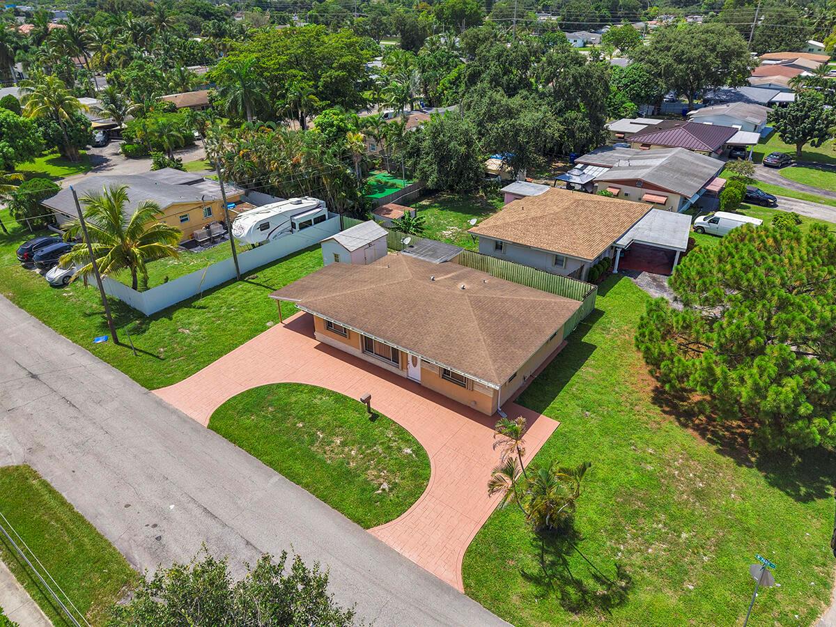 An aerial view shows a single-story house with a brown roof and a paved driveway — 2100 N 57TH Avenue, Hollywood FL 33021, HOLLYWOOD, FL