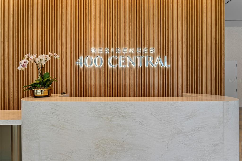 A reception desk with a marble front sits before a wall of vertical wood slats — 400 CENTRAL AVENUE UNIT 3005, ST PETERSBURG, FL