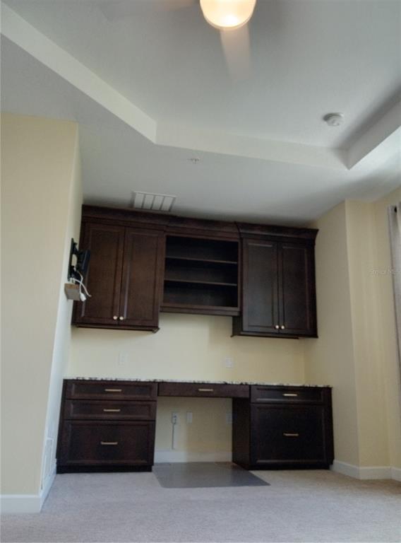 A built-in dark wood desk and cabinetry unit with granite countertops in a carpeted room — 933 BRUTUS TERRACE, LAKE MARY, FL