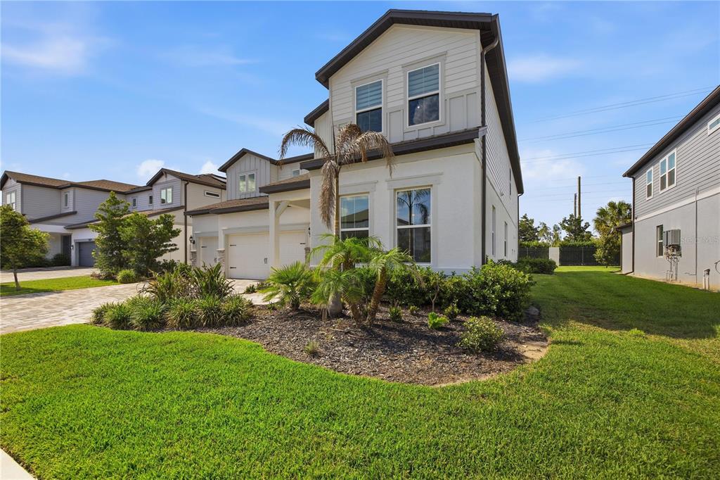 A two-story house with a white stucco facade, a two-car garage, and a landscaped yard — 13816 SHARP HAWK DRIVE, RIVERVIEW, FL