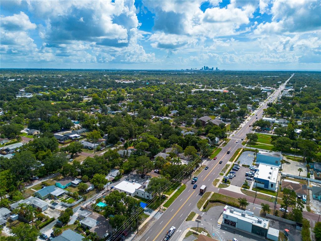 An aerial view shows a suburban neighborhood with a main road and a distant city skyline — 1108 S 55TH STREET, GULFPORT, FL