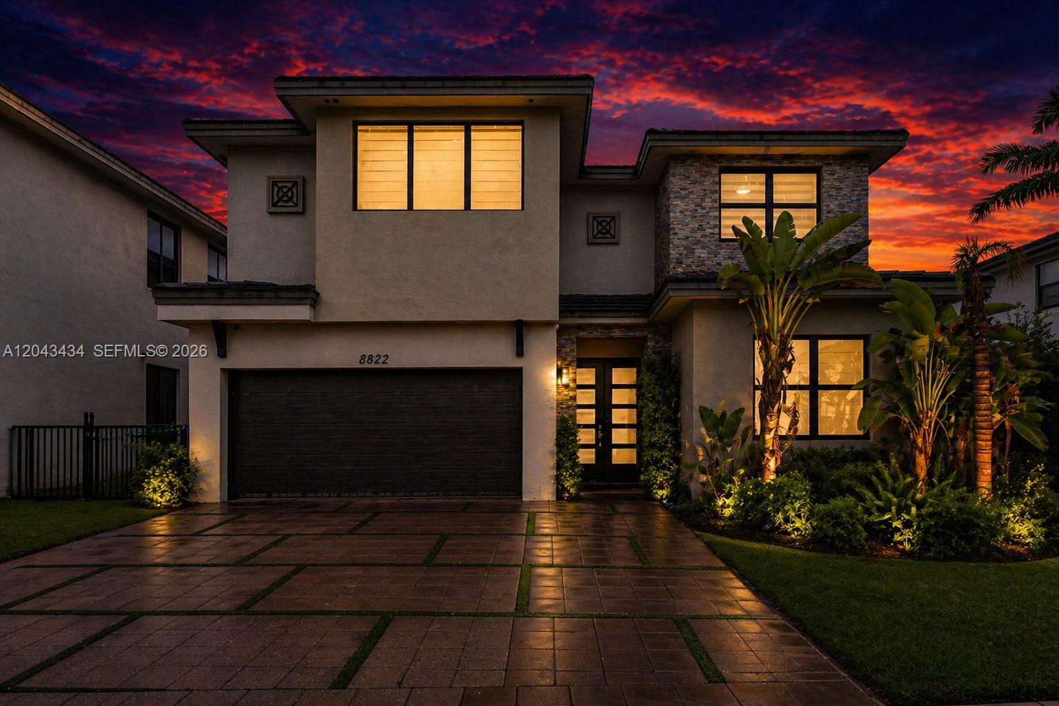 A two-story house exterior features a paved driveway, stone accents, and a dark garage door — 8822 NW 161st Ter, Miami Lakes FL 33018, MIAMI LAKES, FL