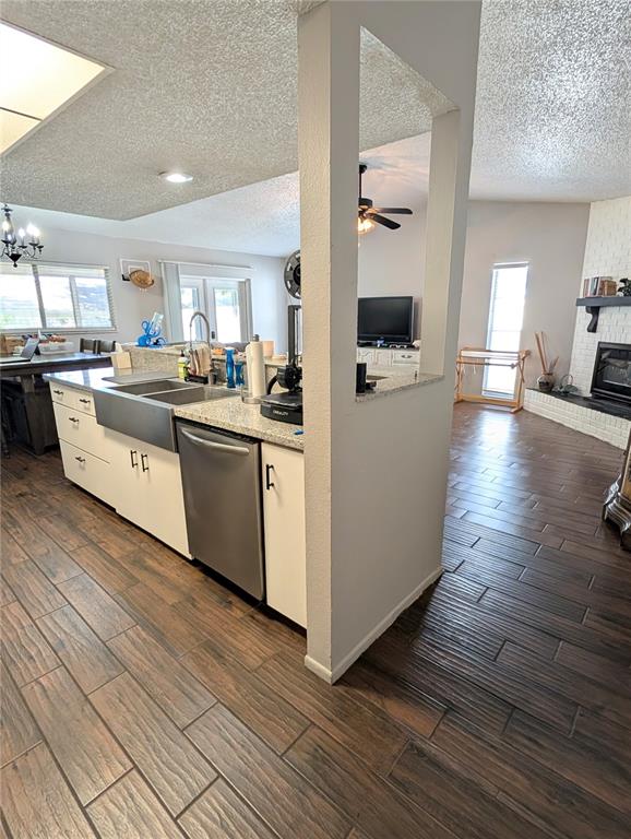 A kitchen island with a farmhouse sink and dishwasher sits next to a living area — 2001 GROVELAND ROAD, PALM HARBOR, FL