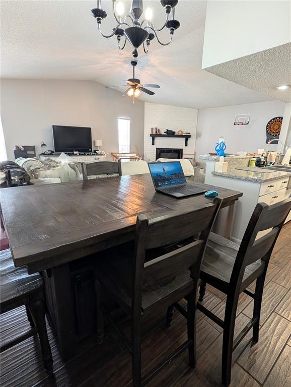 A kitchen island with bar stools sits in front of a living room with a fireplace — 2001 GROVELAND ROAD, PALM HARBOR, FL