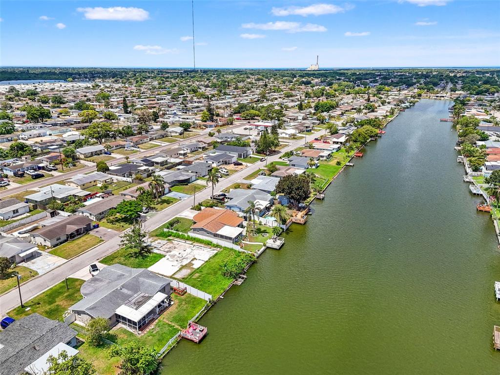 An aerial view shows a residential neighborhood with houses lining a canal — 4101 BADEN DRIVE, HOLIDAY, FL
