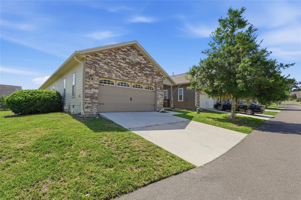 A single-story house with a stone facade, a two-car garage, and a concrete driveway — 1316 NW 120TH WAY, GAINESVILLE, FL