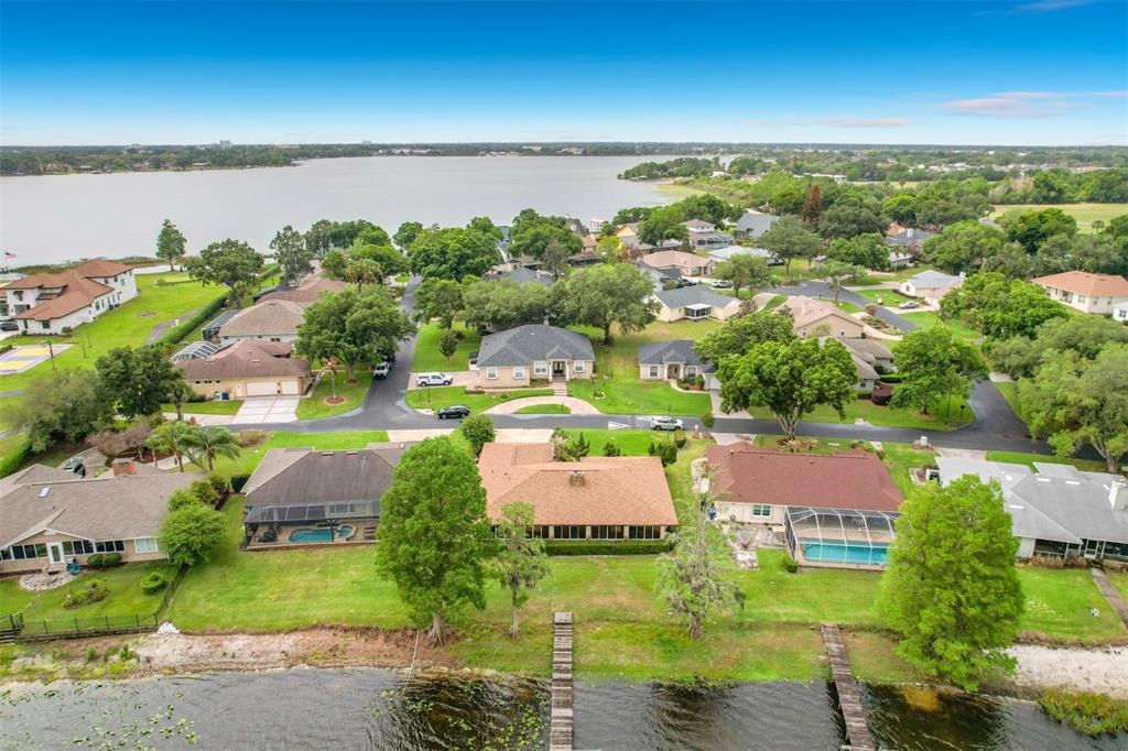 An aerial view shows several waterfront homes with swimming pools and private docks on a lake — 247 S LAKE PANSY DRIVE, WINTER HAVEN, FL