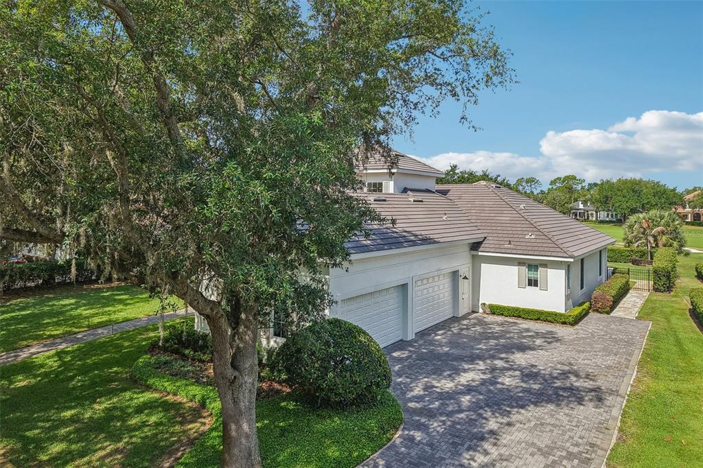 An aerial view of a white house with a tiled roof and a paved driveway — 6120 GREATWATER DR, WINDERMERE, FL