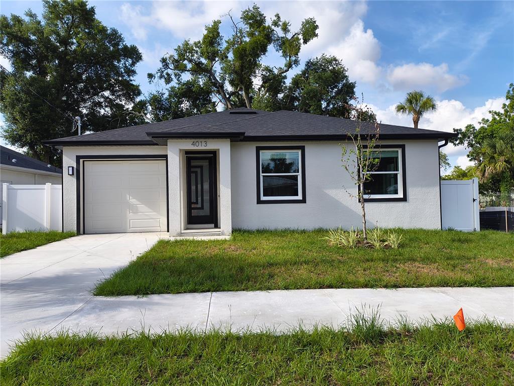 A single-story house with a white stucco exterior, black trim, and a one-car garage — 4013 E CURTIS STREET, TAMPA, FL