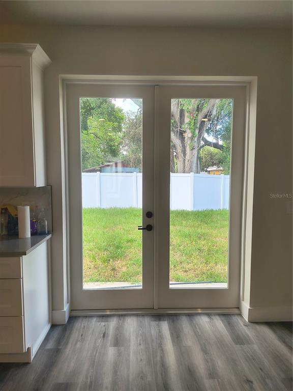 A kitchen area features a white double door leading to a fenced backyard — 4013 E CURTIS STREET, TAMPA, FL