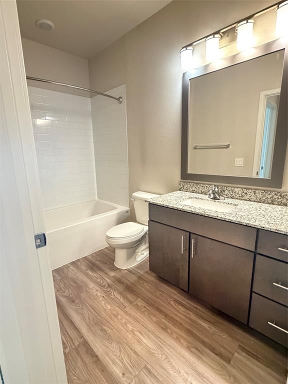 A bathroom features a vanity with a granite countertop, a toilet, and a tiled tub — 510 ACADEMY DRIVE UNIT 303, KISSIMMEE, FL