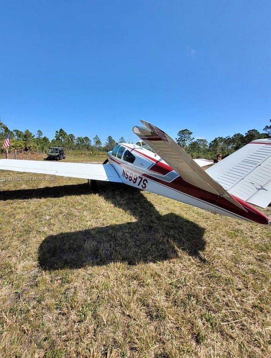 A small, white and red private airplane is parked on a grassy field — 1000 NE 365 Lane, Okeechobee FL 34972, OKEECHOBEE, FL