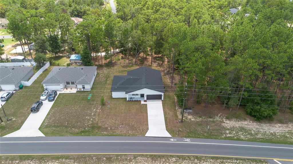 An aerial view shows a single-story house with a dark roof and concrete driveway — 1028 W CITRUS SPRINGS BOULEVARD, CITRUS SPRINGS, FL